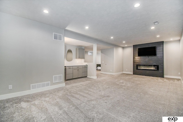 unfurnished living room featuring light carpet and a fireplace