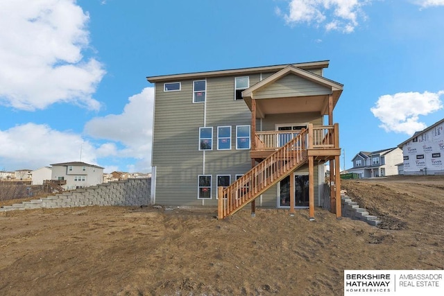 rear view of property featuring stairs and fence