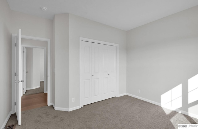 unfurnished bedroom with carpet floors and a closet