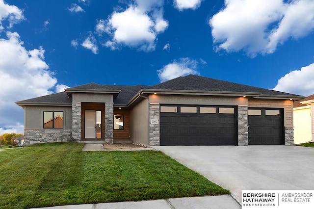 prairie-style house featuring a garage and a front lawn