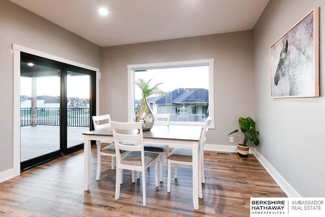 dining space with wood-type flooring