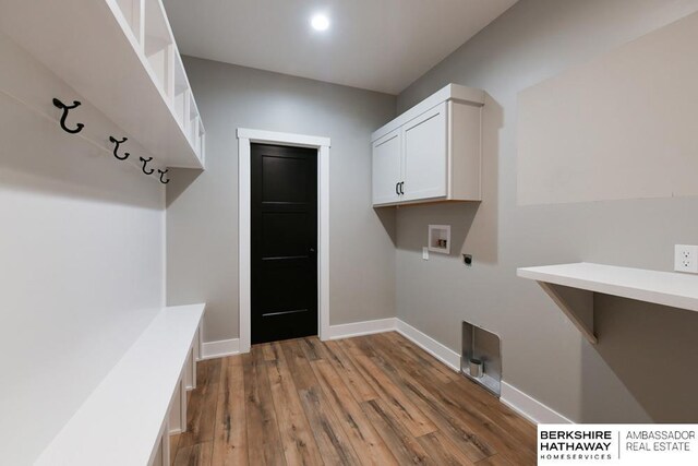 clothes washing area with cabinets, hookup for a washing machine, light wood-type flooring, and electric dryer hookup