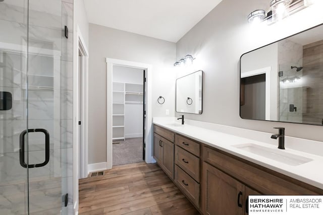 bathroom with vanity, hardwood / wood-style flooring, and a shower with door