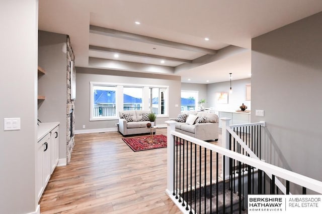 living room with beam ceiling and light wood-type flooring