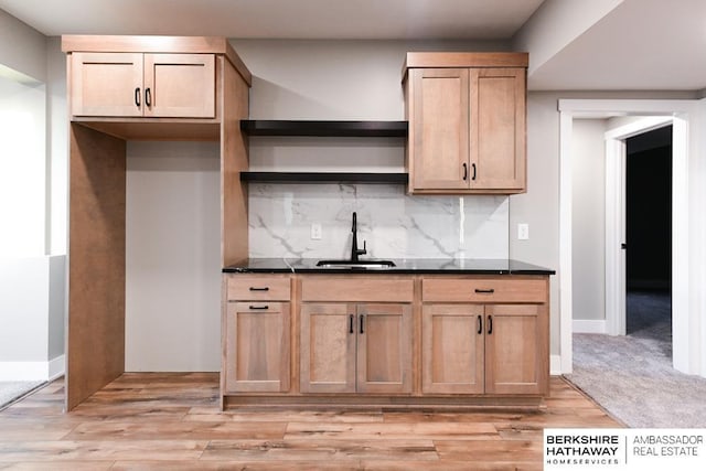 kitchen featuring backsplash, light brown cabinetry, sink, and light carpet