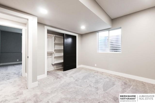 unfurnished bedroom with a closet and light colored carpet