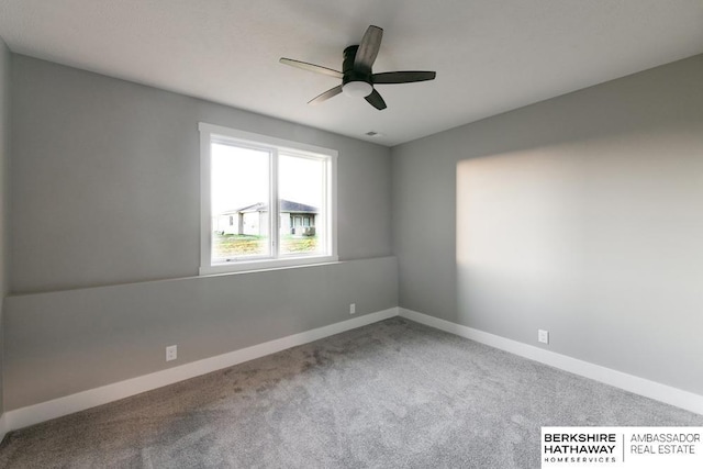 carpeted spare room featuring ceiling fan