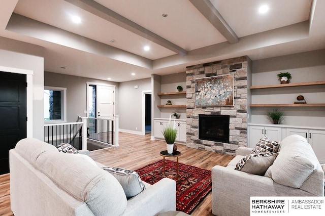 living room with a fireplace, light hardwood / wood-style floors, built in features, and beamed ceiling