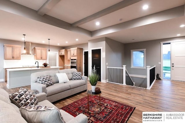 living room featuring beam ceiling and light wood-type flooring