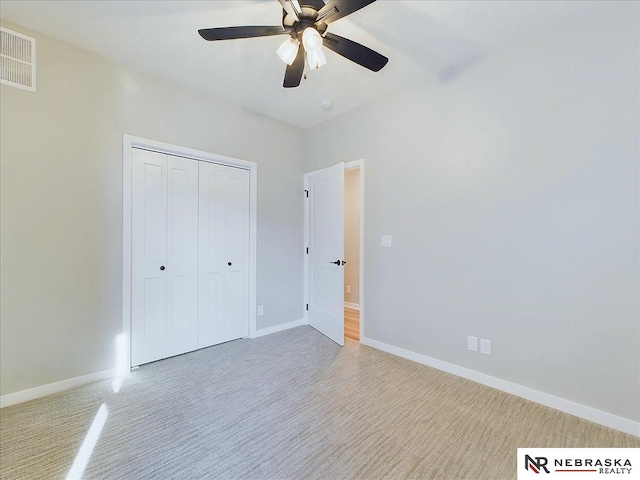 unfurnished bedroom with ceiling fan and a closet