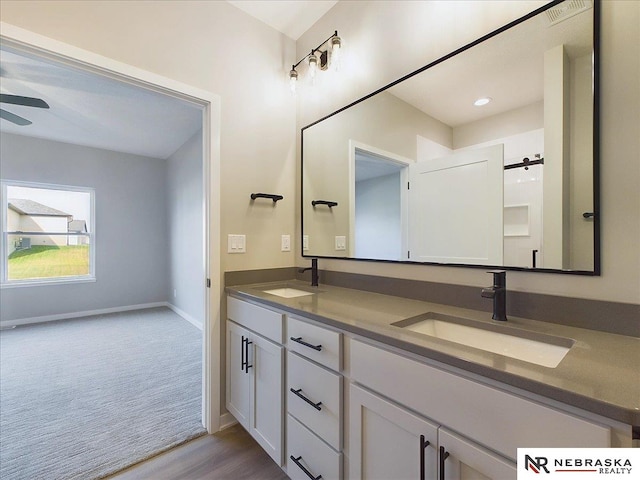 bathroom featuring hardwood / wood-style flooring, vanity, and ceiling fan