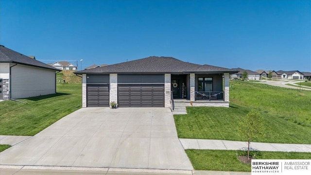 prairie-style home featuring a porch, a garage, and a front lawn