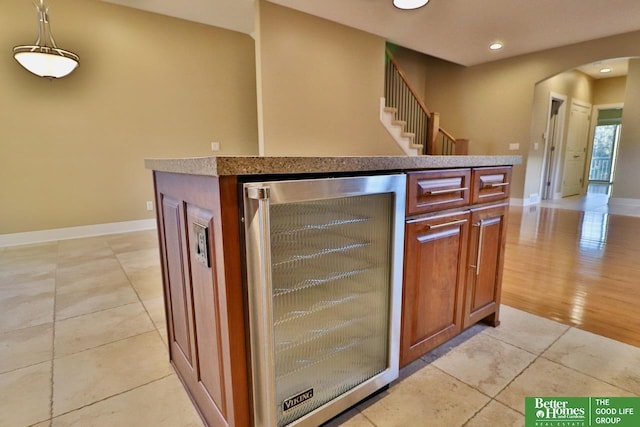 interior space featuring wine cooler, light tile patterned flooring, and hanging light fixtures