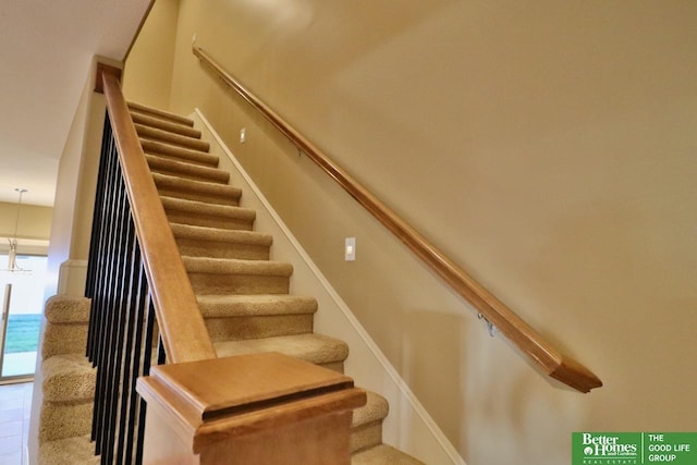 stairs with a notable chandelier