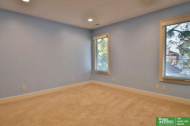 unfurnished room with plenty of natural light and light colored carpet