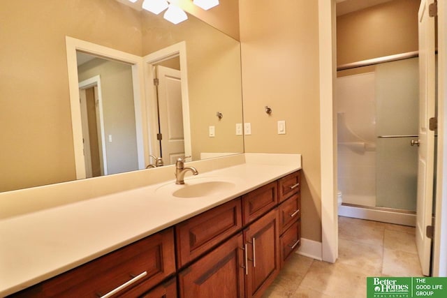 bathroom featuring tile patterned floors, vanity, toilet, and a shower with shower door