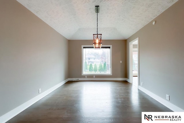 unfurnished dining area with dark hardwood / wood-style floors and a textured ceiling