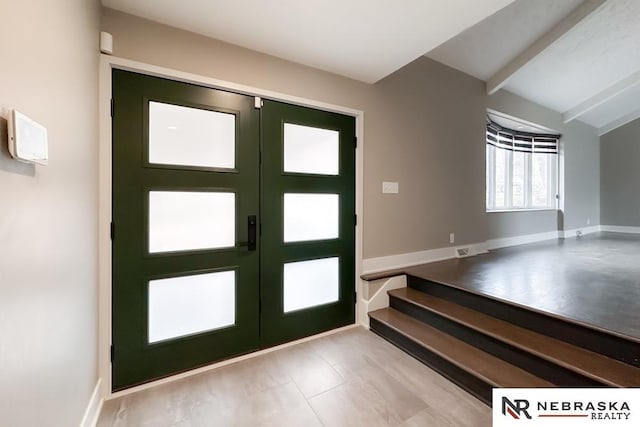 entrance foyer featuring french doors and lofted ceiling with beams