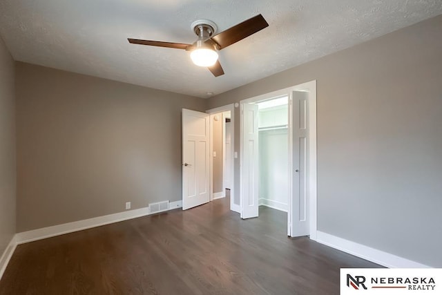 unfurnished bedroom featuring ceiling fan, dark hardwood / wood-style floors, a textured ceiling, and a closet