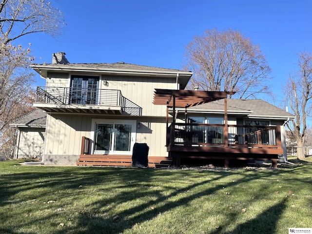 back of property with a lawn, a balcony, a pergola, and a wooden deck