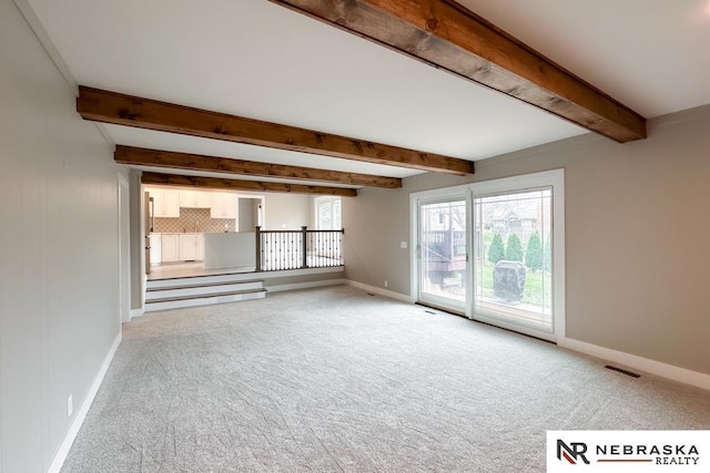 unfurnished living room featuring light carpet and beam ceiling