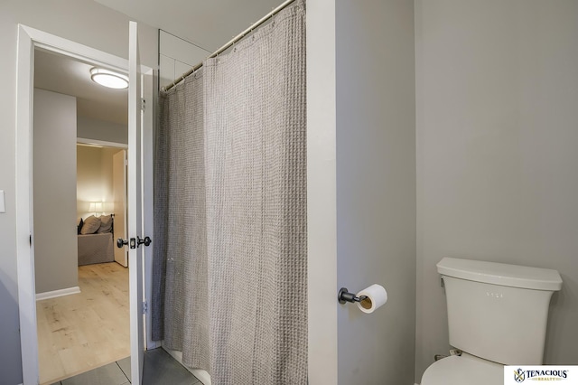 bathroom featuring a shower with shower curtain and toilet