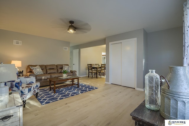 living room with light wood-type flooring and ceiling fan