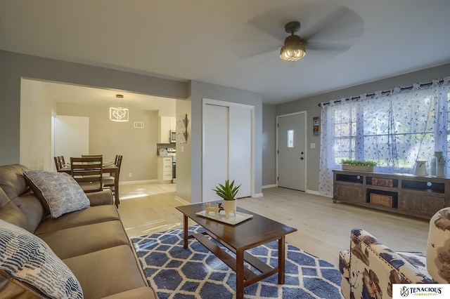 living room with ceiling fan and light hardwood / wood-style floors