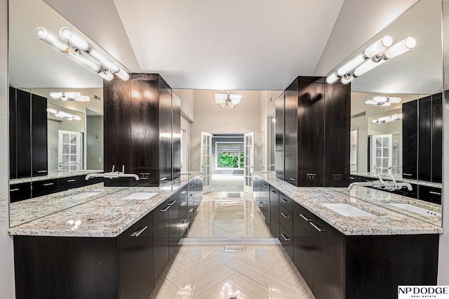 bathroom featuring vanity, lofted ceiling, and a notable chandelier