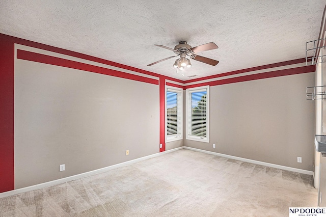 empty room featuring a textured ceiling, carpet floors, and ceiling fan