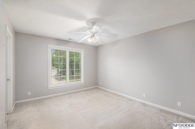 carpeted spare room with ceiling fan and a textured ceiling