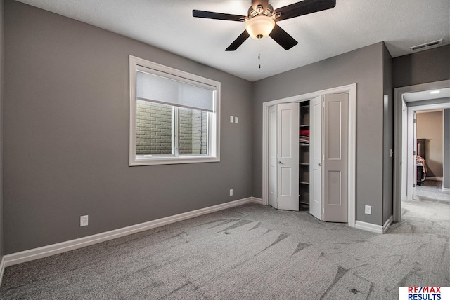 unfurnished bedroom featuring ceiling fan, a closet, and light colored carpet