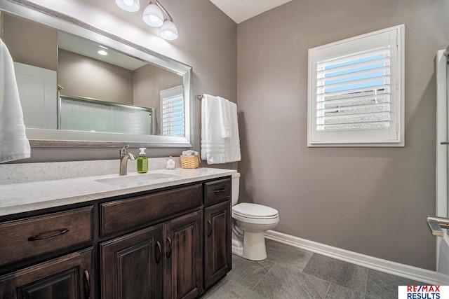 bathroom featuring toilet, vanity, and walk in shower