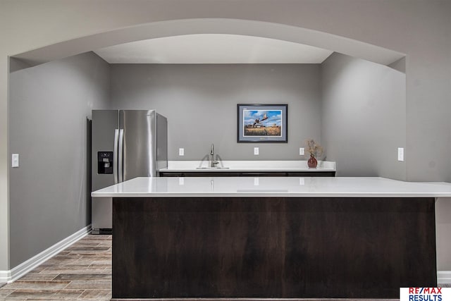 kitchen with stainless steel fridge, sink, and light hardwood / wood-style flooring