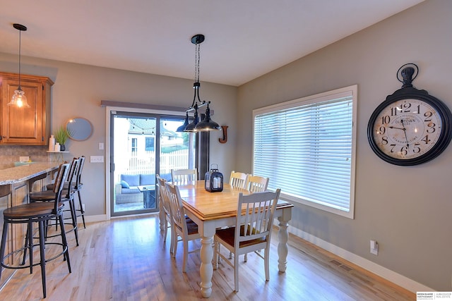 dining room featuring light wood-style floors, visible vents, and baseboards