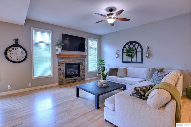 living room featuring light wood finished floors, baseboards, and a ceiling fan