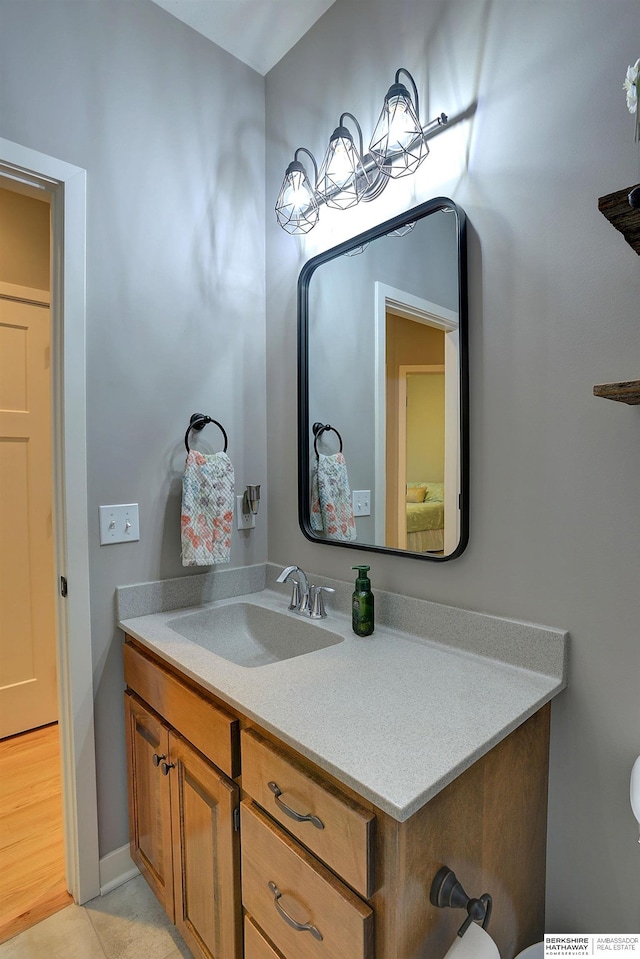 bathroom featuring tile patterned flooring, vanity, and toilet