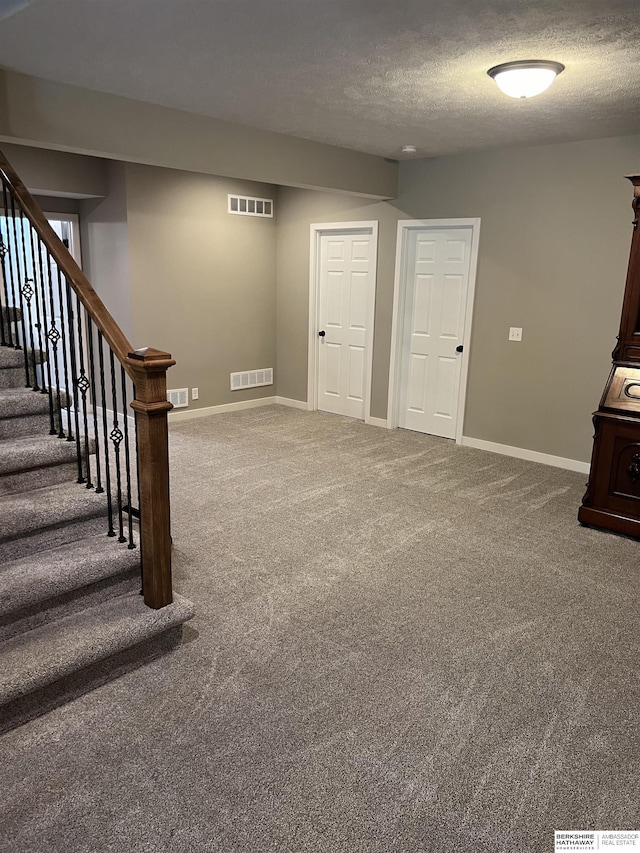 basement featuring carpet flooring and visible vents