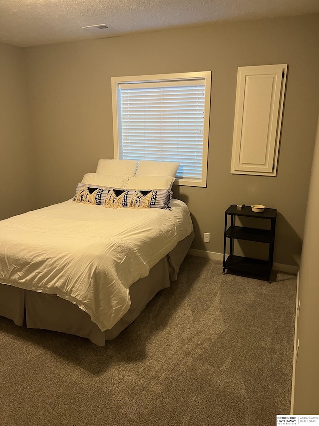 bedroom featuring a textured ceiling and carpet floors