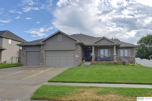 view of front of house featuring a front yard, fence, driveway, a porch, and an attached garage