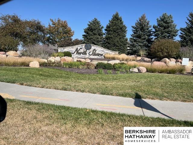 community sign featuring a lawn