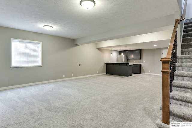 unfurnished living room featuring a textured ceiling and light colored carpet