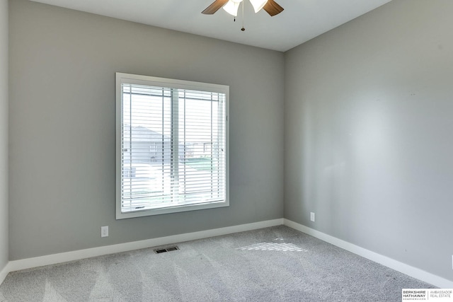 spare room featuring visible vents, baseboards, a ceiling fan, and carpet flooring