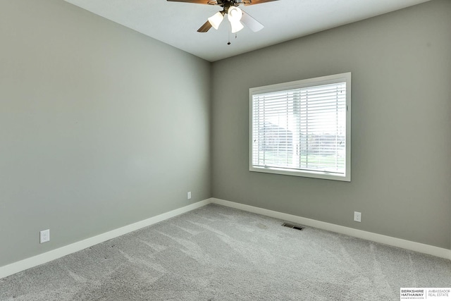 carpeted empty room with visible vents, a ceiling fan, and baseboards