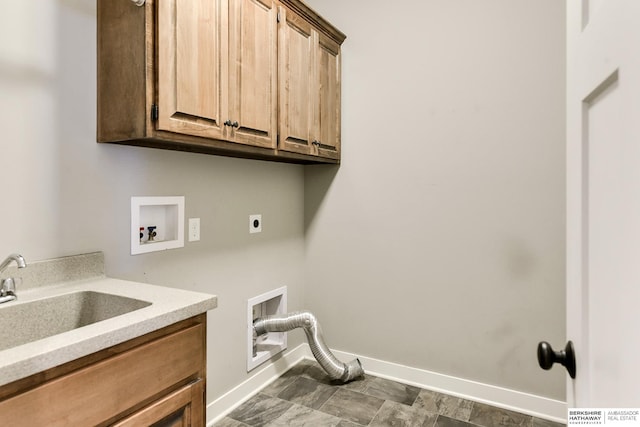 washroom with baseboards, cabinet space, a sink, washer hookup, and electric dryer hookup