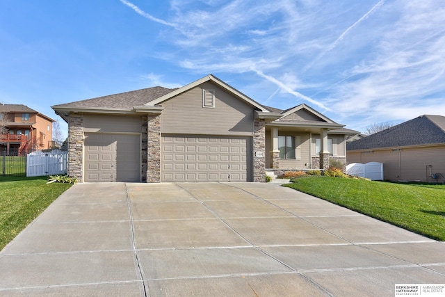 view of front facade with a garage, driveway, a front yard, and fence