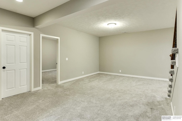 interior space featuring carpet flooring, a textured ceiling, and baseboards