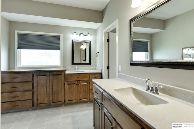 full bath featuring tile patterned flooring, two vanities, and a sink