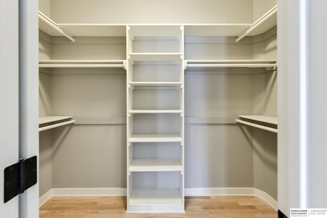 walk in closet with wood finished floors