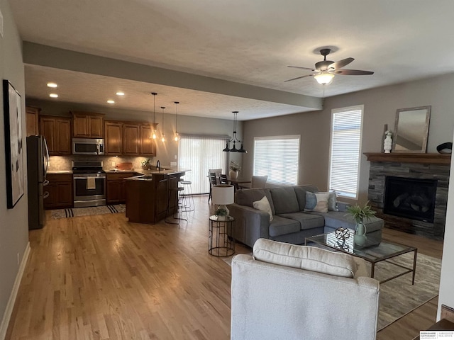 living area featuring recessed lighting, baseboards, a healthy amount of sunlight, and light wood finished floors